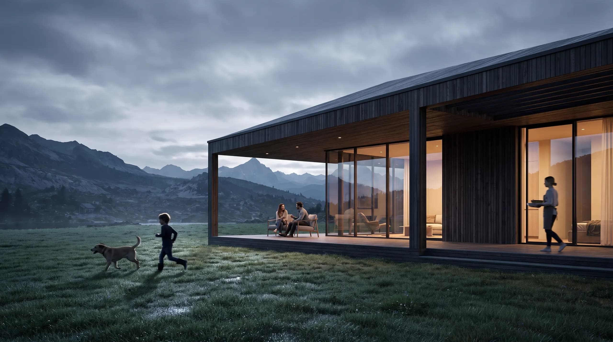 The finished timber home in the meadow at dusk, a couple on the terrace, a child and a dog running on the grass